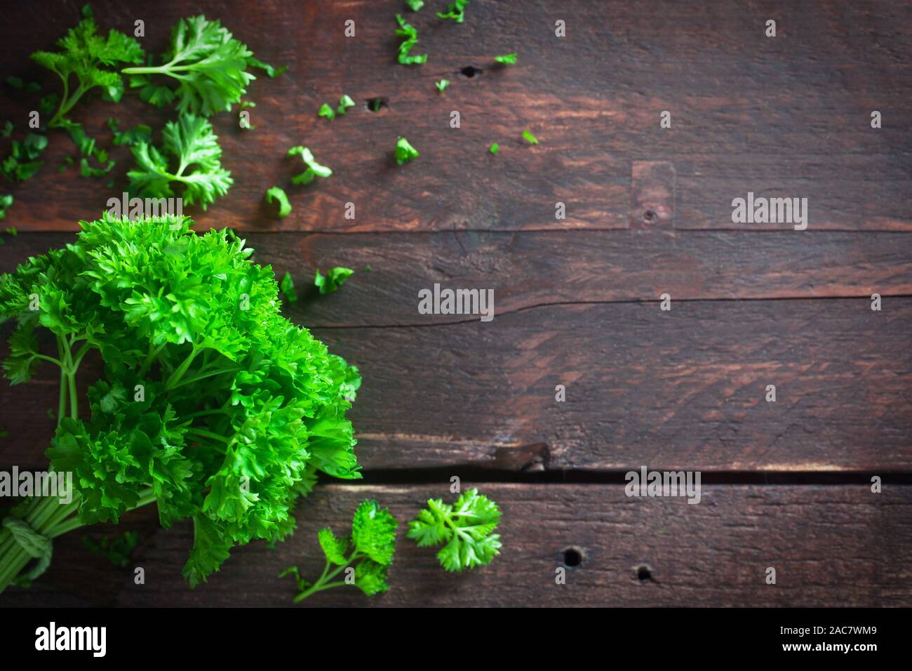 Un mazzetto di prezzemolo su uno sfondo di legno Foto Stock