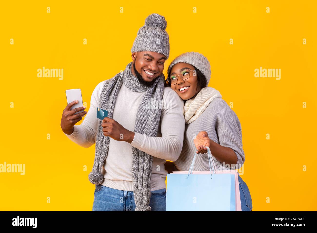 Allegro l uomo e la donna che effettuano acquisti tramite telefono Foto Stock