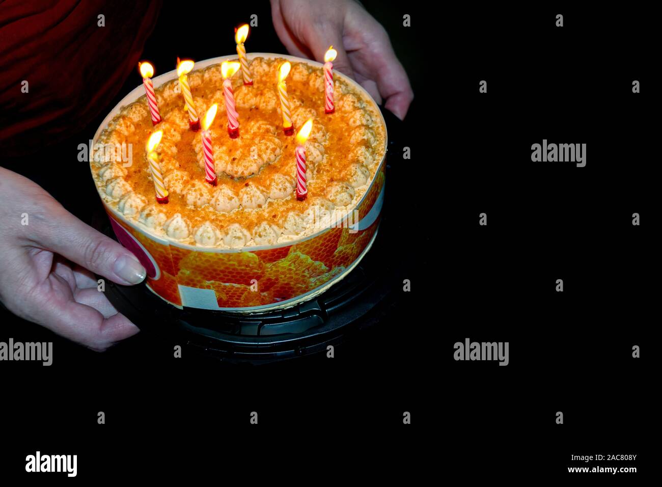 Donna mano che tiene una torta di compleanno per bambini. Foto Stock