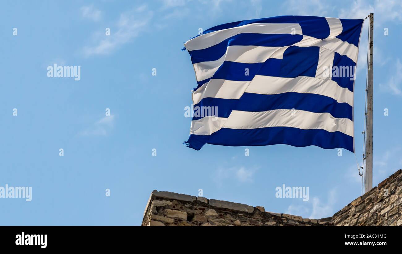 Nazionale Greco di bandiera sventola sul cielo blu sullo sfondo. Repubblica Ellenica, GR Foto Stock