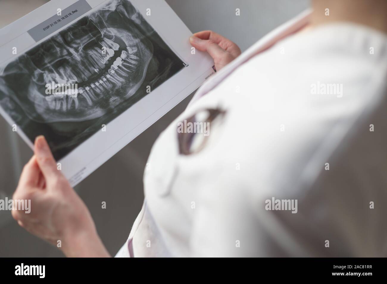 Dentista femmina guardando immagine a raggi x. Foto Stock