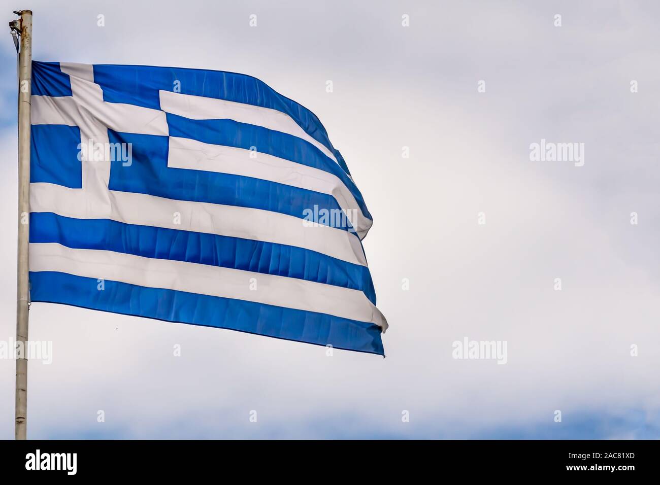 Nazionale Greco di bandiera sventola sul cielo blu sullo sfondo. Repubblica Ellenica, GR Foto Stock
