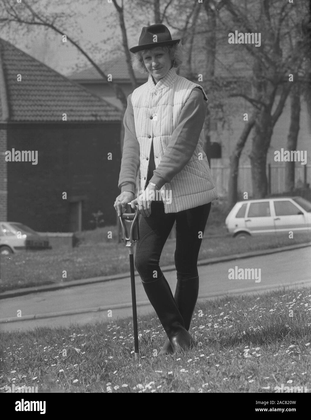 Anni ottanta, storico, una signora con un bastone di ripresa la modellazione di alcuni dei più recenti countrywear britannica, Inghilterra, Regno Unito. Foto Stock