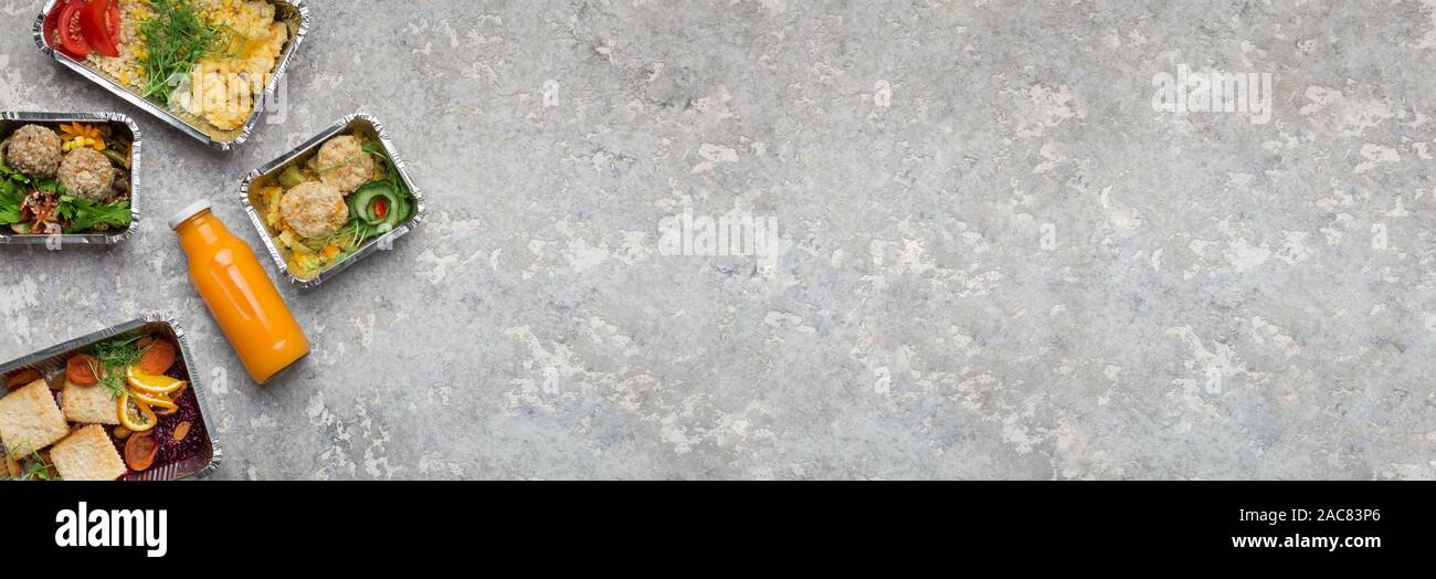 Un assortimento di pasti in contenitori con fresco frullato arancione Foto Stock