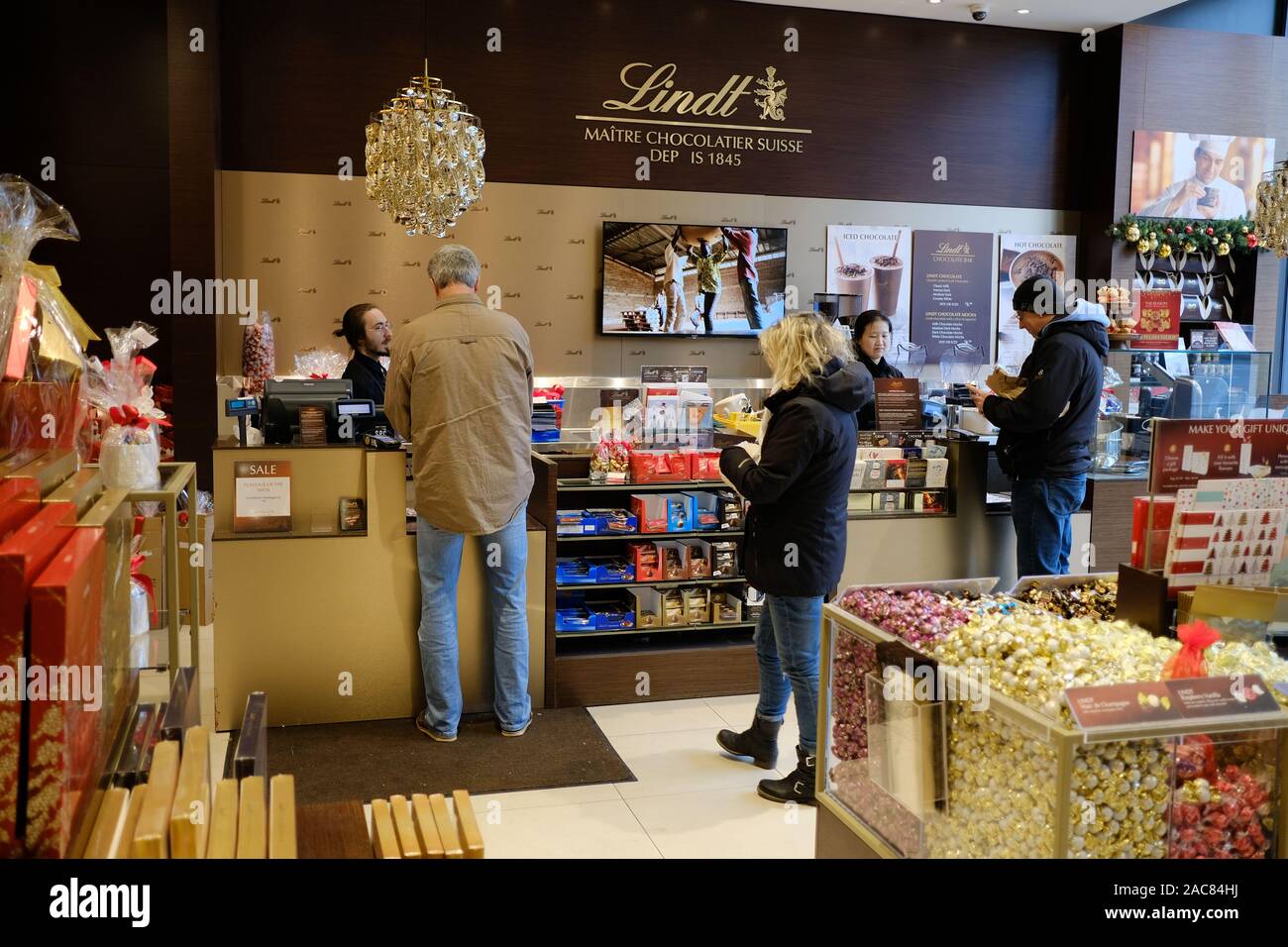 Lindt Chocolate store delight - agli acquirenti di acquistare regali per Natale. Non ci sono bambini in questo negozio di caramelle! Lansdowne, Ottawa, Ontario, Canada. Foto Stock