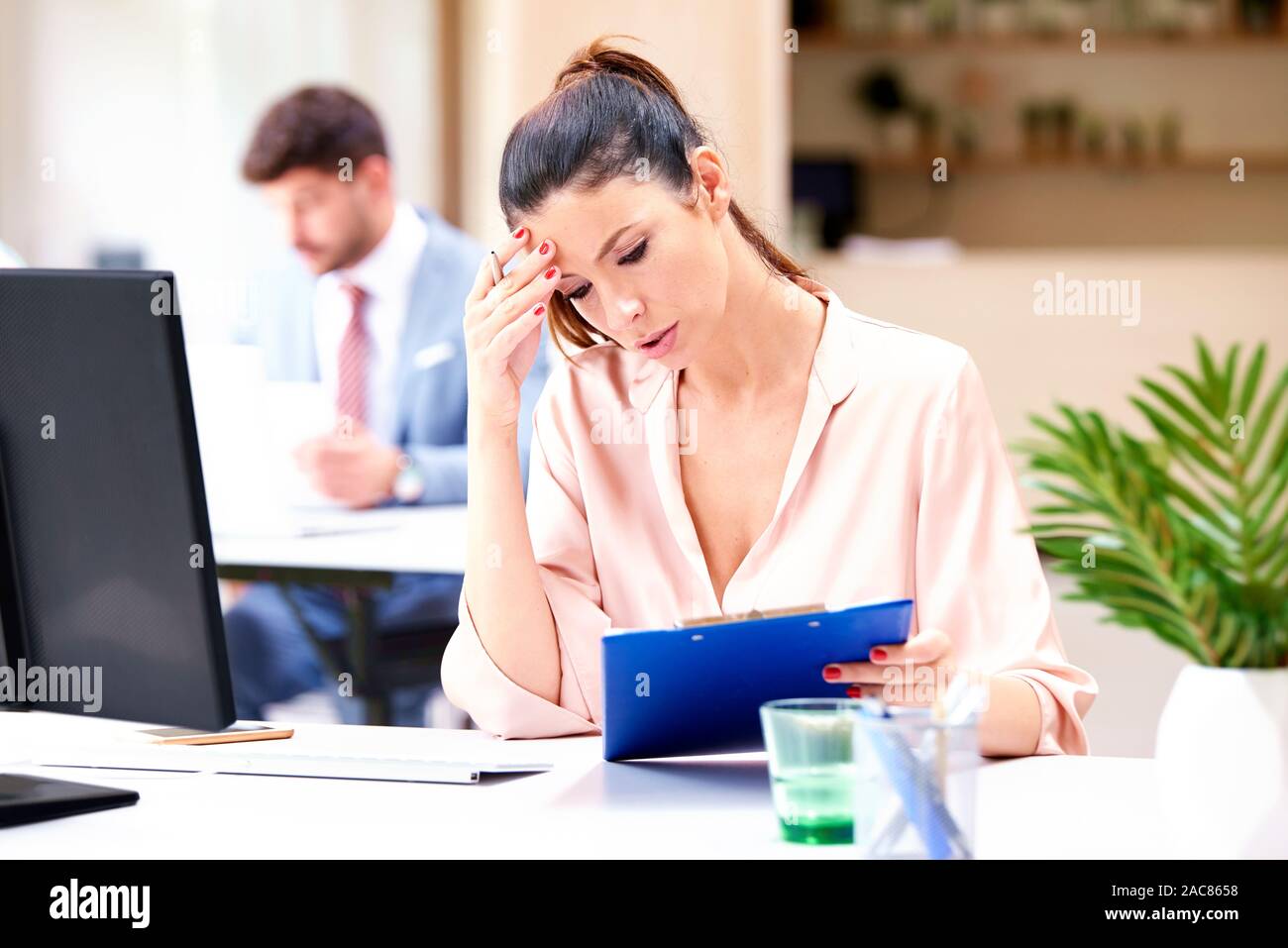 Colpo di preoccupato imprenditrice seduto alla scrivania in ufficio al computer e lavorare sul progetto di business. Foto Stock