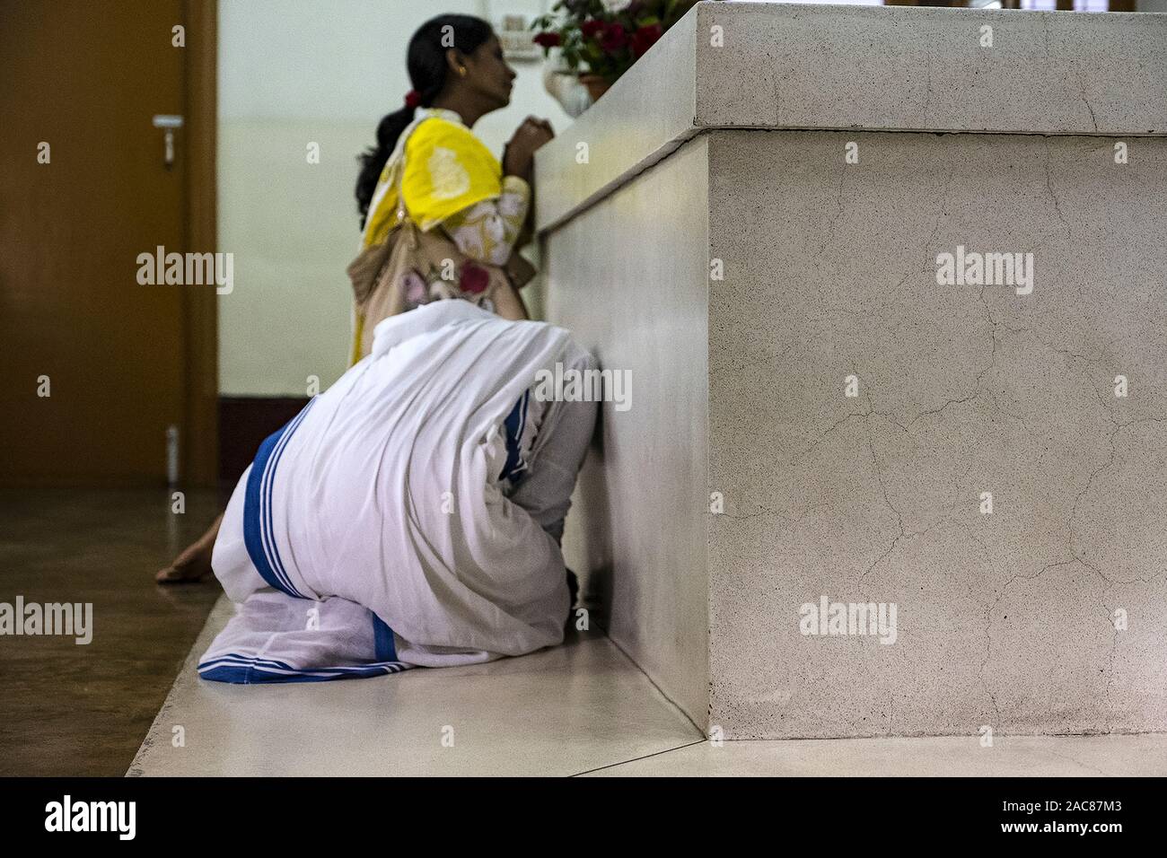 Madre Teresa la sorella di pregare presso la tomba nella casa madre situata in Kolkata, India Foto Stock