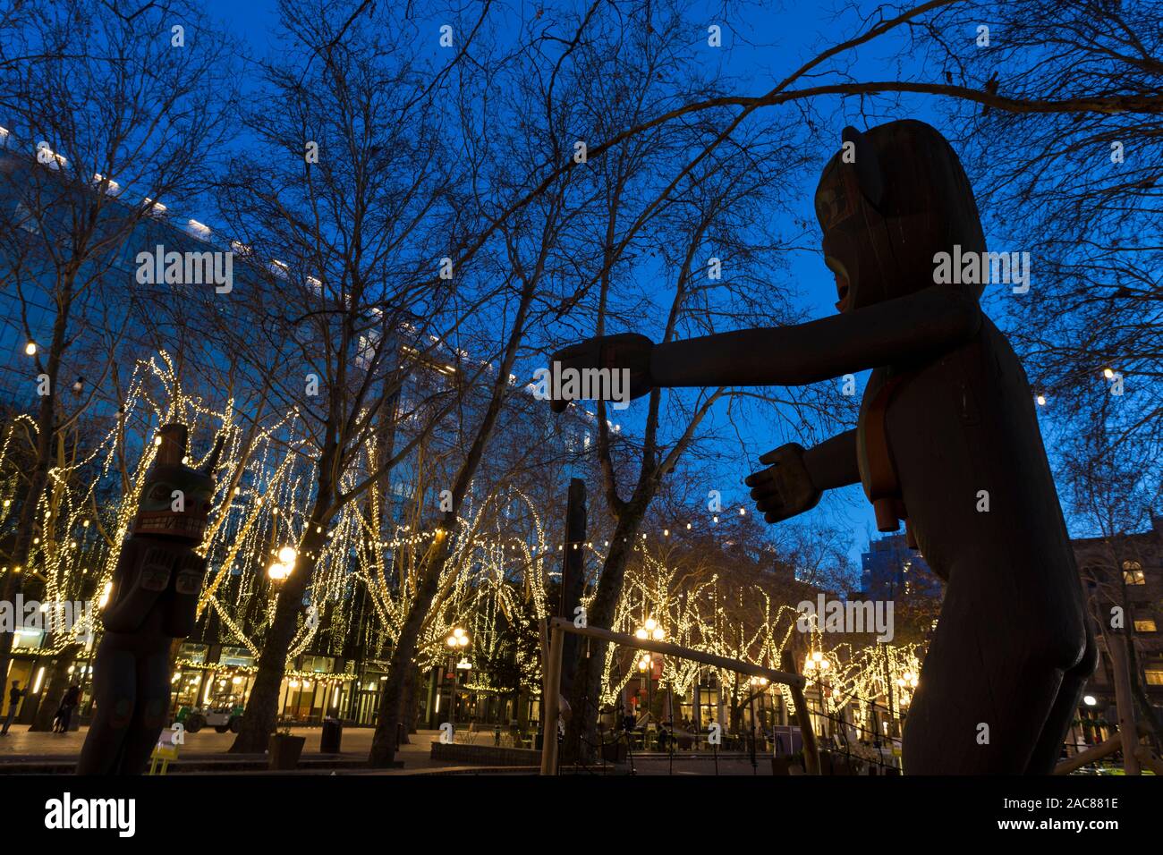 Duane Pasco il totem stagliano by Occidental del quadrato luci delle vacanze a Seattle la storica Pioneer Square quartiere Novembre 30, 2019. Foto Stock