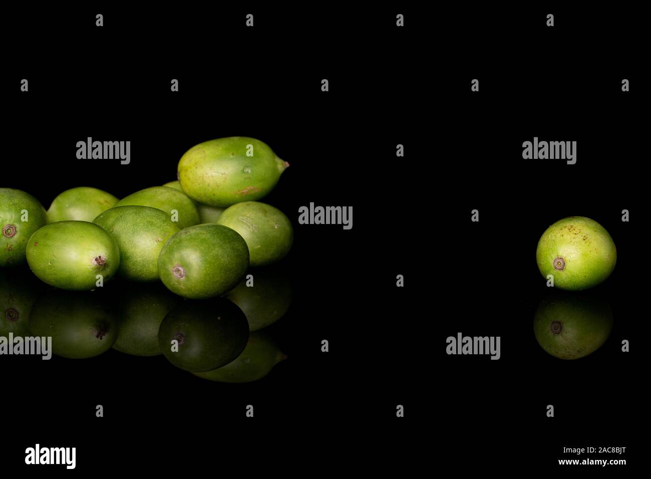 Sacco di tutta hardy kiwi verde isolato sul vetro nero Foto Stock
