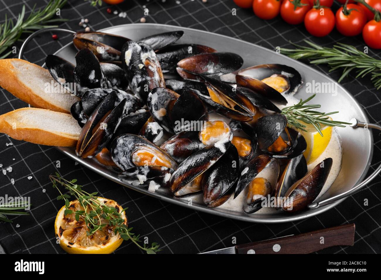 Cozze cotte in una salsa. Foto Stock