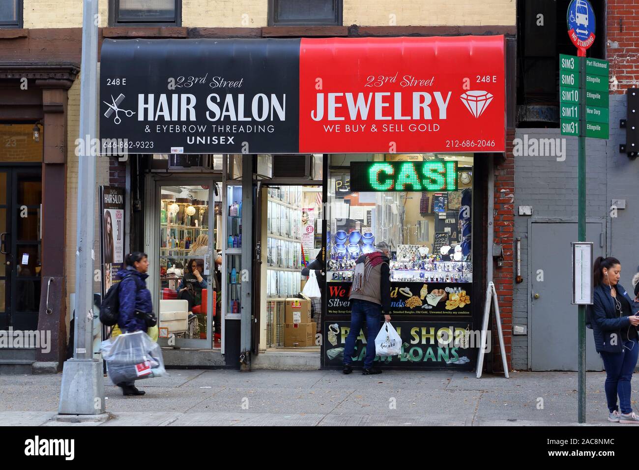 Un parrucchiere e un negozio di pegni su East 23rd St, Manhattan, New York, NY Foto Stock