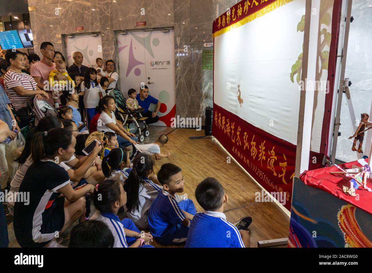Affascinare famiglie cinesi ombra guardare uno spettacolo di burattini Foto Stock
