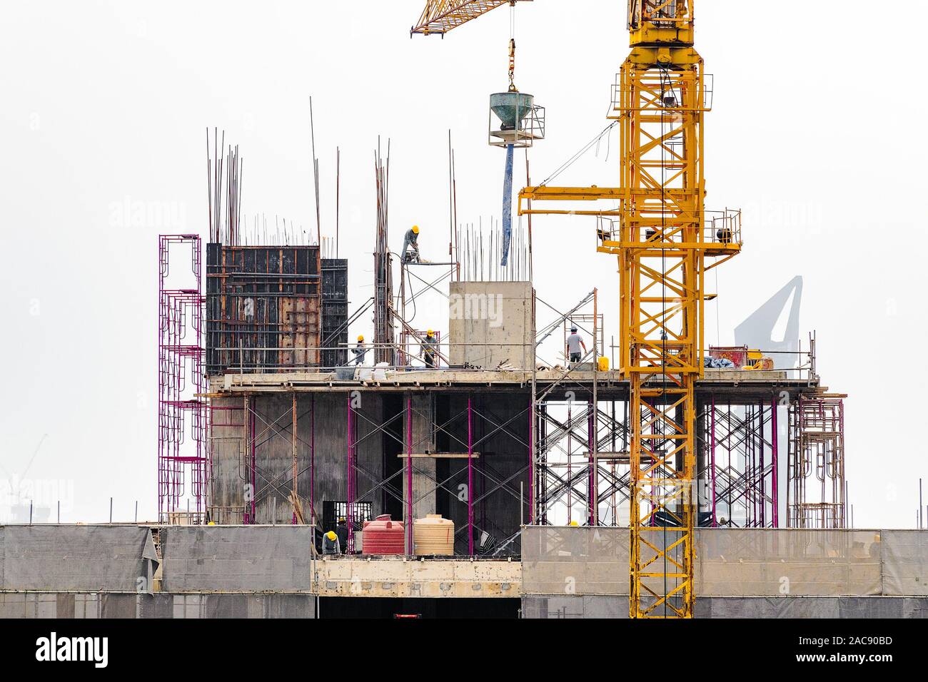 Vista aerea di una costruzione edilizia con gru a torre, ponteggi, casseforme, attrezzature e gli equipaggi di lavoro Immissione di rinforzo barre di acciaio. Foto Stock