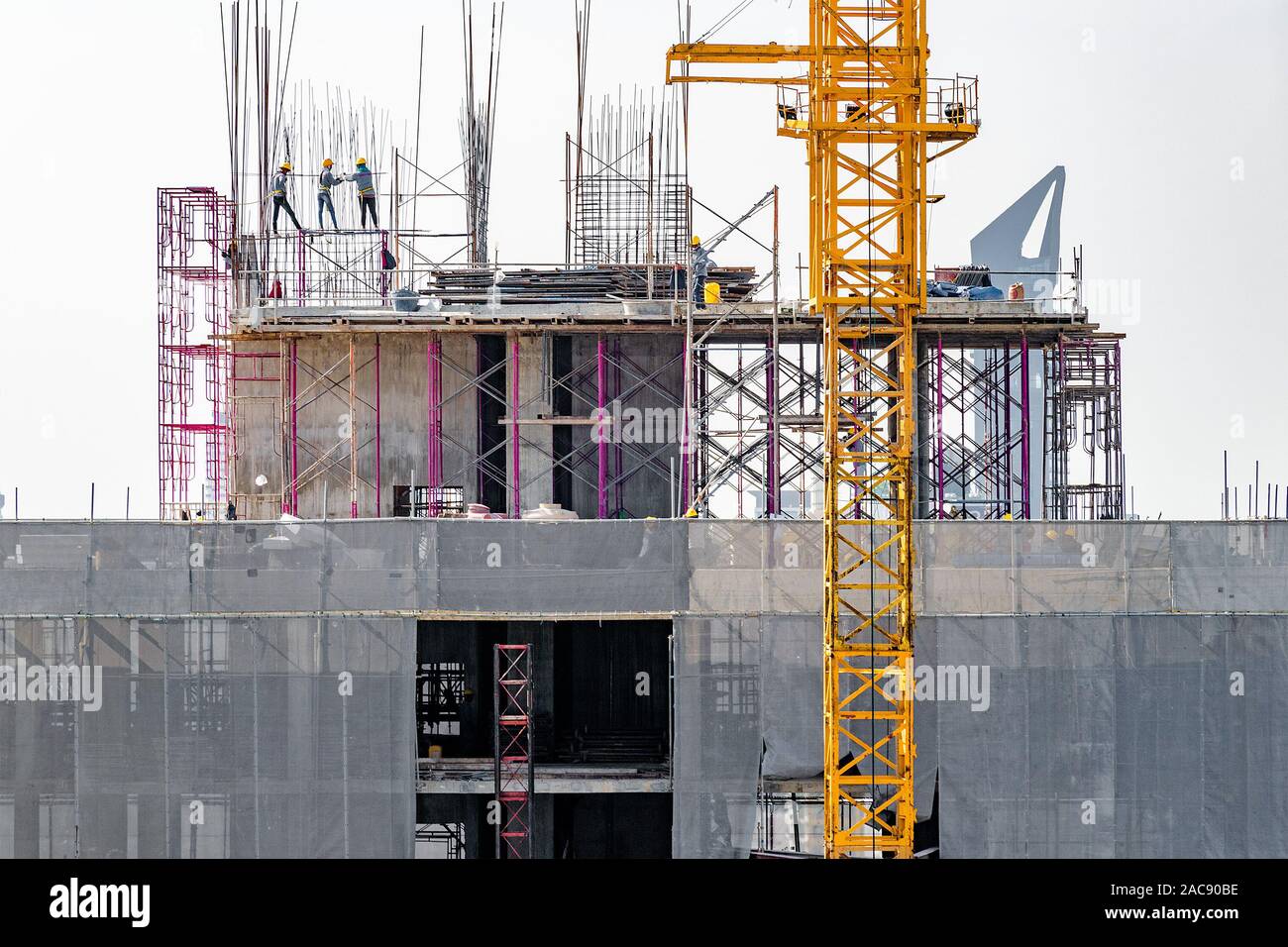 Vista aerea di una costruzione edilizia con gru a torre, ponteggi, casseforme, attrezzature e gli equipaggi di lavoro Immissione di rinforzo barre di acciaio. Foto Stock