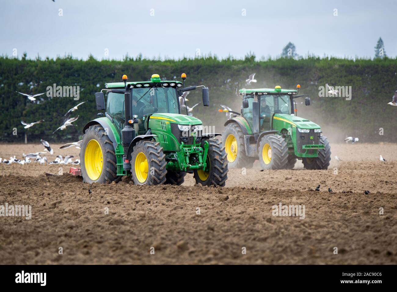 Sheffield, Canterbury, Nuova Zelanda, 30 Novembre 2019: trattori John Deere a lavorare in un campo a coltivare il suolo pronto per le patate devono essere piantate Foto Stock