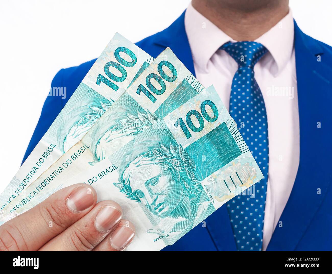 Real brasiliano - valuta brasiliana. Uomo che indossa indossare giacca e cravatta tenendo alcune bollette di denaro. Foto Stock