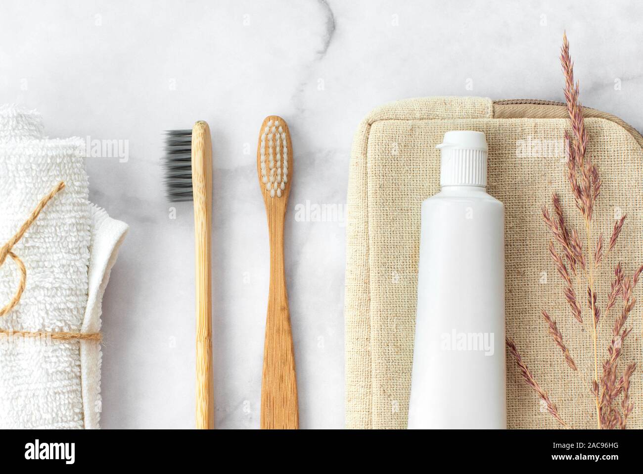 Set di eco-friendly spazzolini da denti e dentifricio e panno di cotone su sfondo marmo. Dentale e concetto di assistenza sanitaria. Vista superiore, piatto laici. Foto Stock