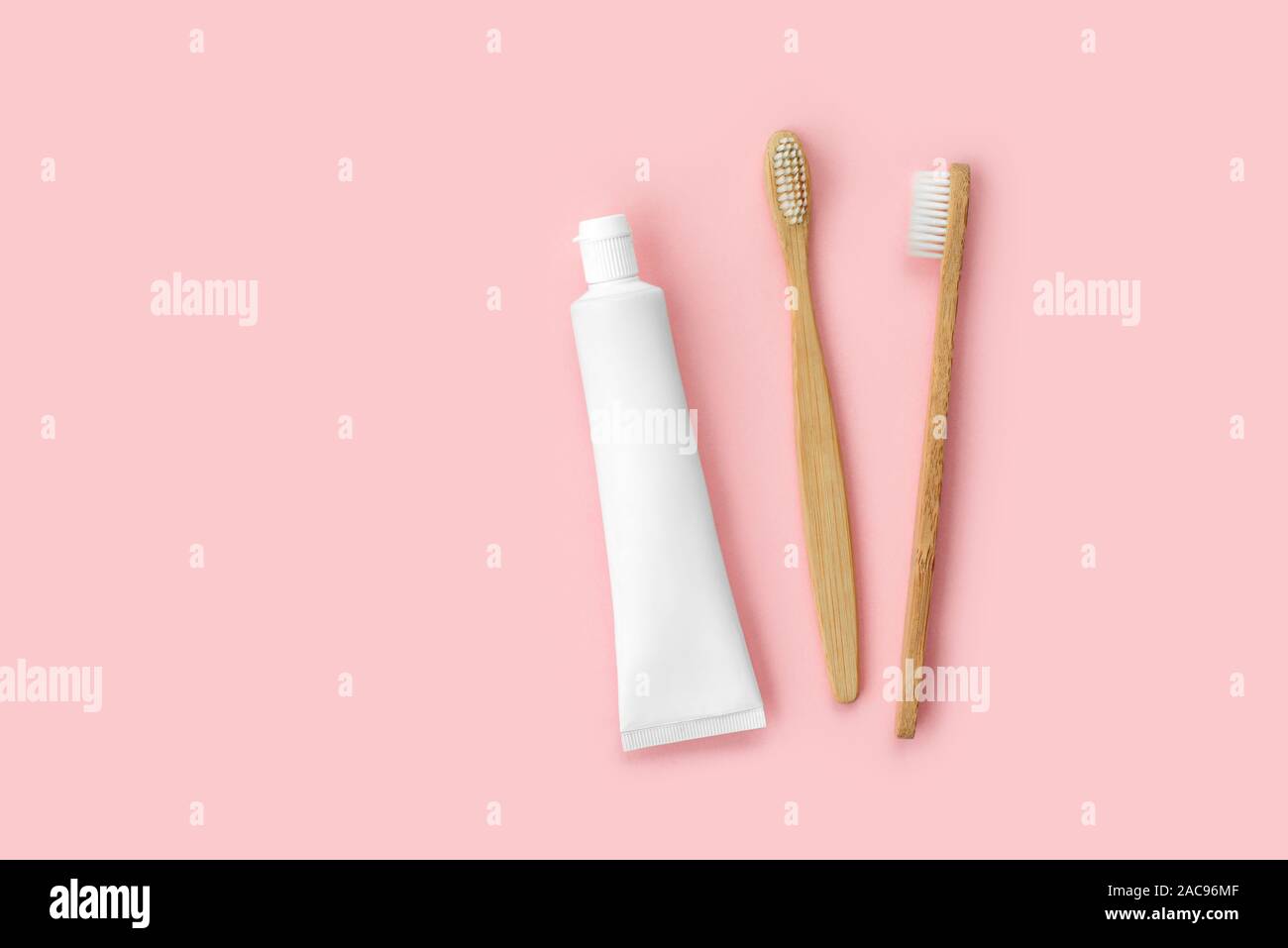 Set di eco-friendly spazzolini da denti e dentifricio su sfondo rosa. Dentale e concetto di assistenza sanitaria. Vista superiore, piatto laici. Copia gratuita dello spazio. Foto Stock