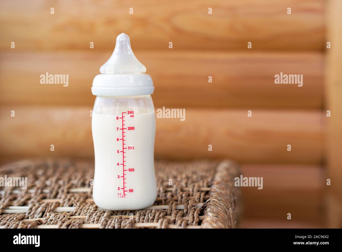 Bottiglia con latte materno per bambino su sfondo di legno. La maternità e la cura del bambino concetto. Vista dall'alto. Copia gratuita dello spazio. Foto Stock