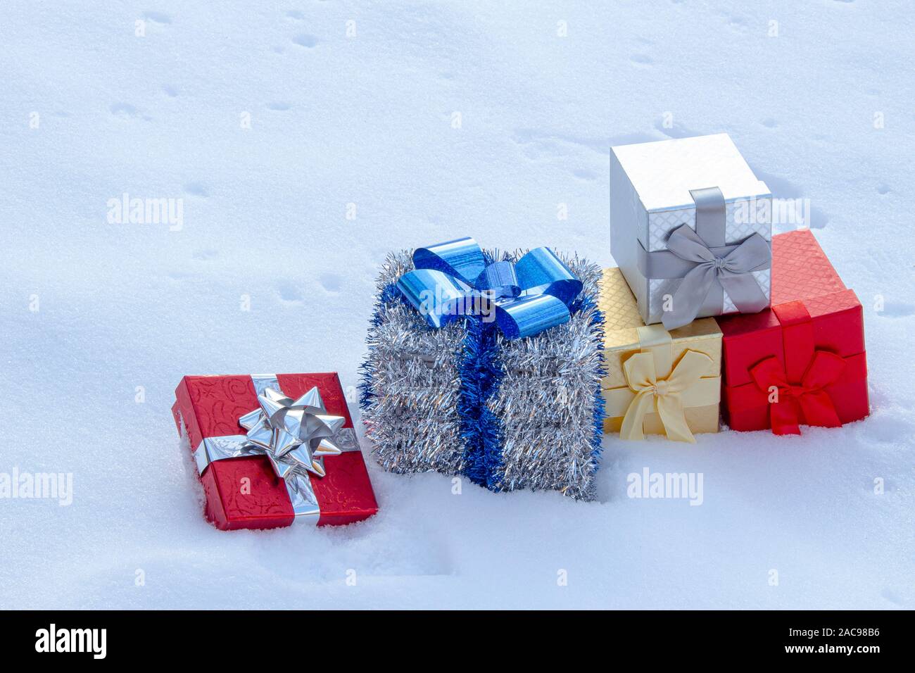 Colorate scatole Gif presenta sulla scorta di neve su ciascun altro Foto Stock