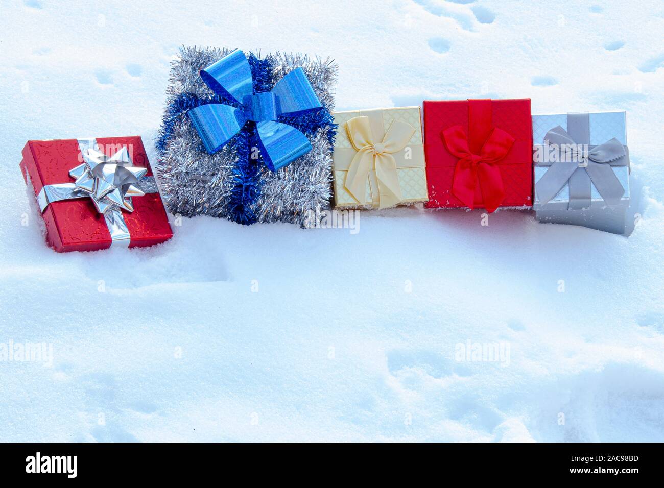 Colorate scatole regalo presenta sulla neve Foto Stock