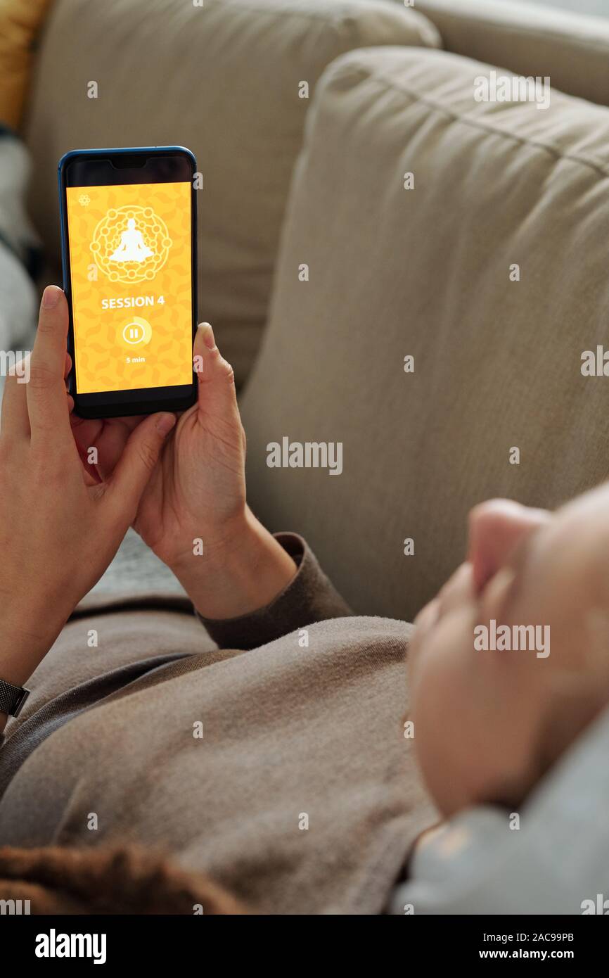 Le mani delle donne con lo smartphone andando a prendere la sessione di online corso di yoga Foto Stock