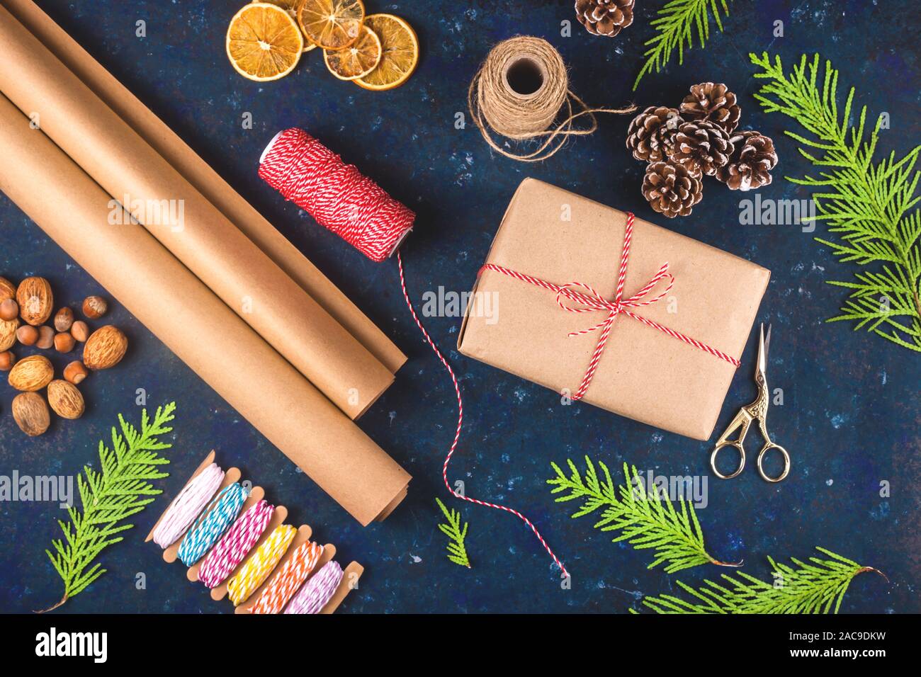 La forma rotonda costituito da polvere di zucchero a velo per la cottura su un tavolo blu tra Natale rami di abete e bacche rosse. Vista superiore, piatto laici. Foto Stock