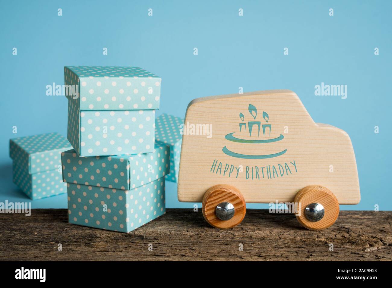 Confezioni regalo e giocattoli in legno auto con la scritta "Happy Birthday" impresso sul lato del modello. Concetto di biglietto di auguri. Foto Stock