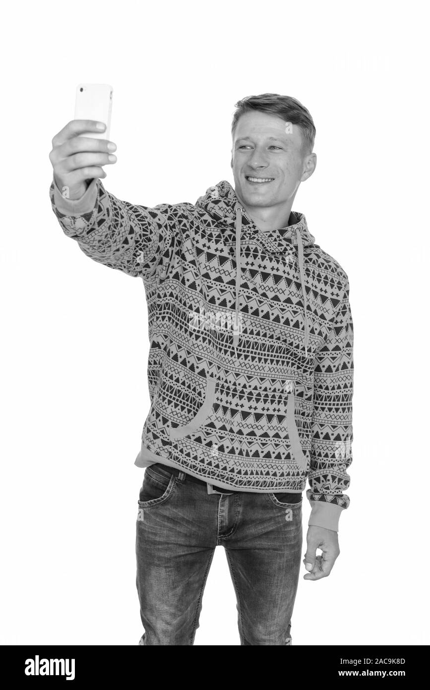 Studio shot di giovani felici uomo caucasico tenendo selfie isolata contro uno sfondo bianco Foto Stock