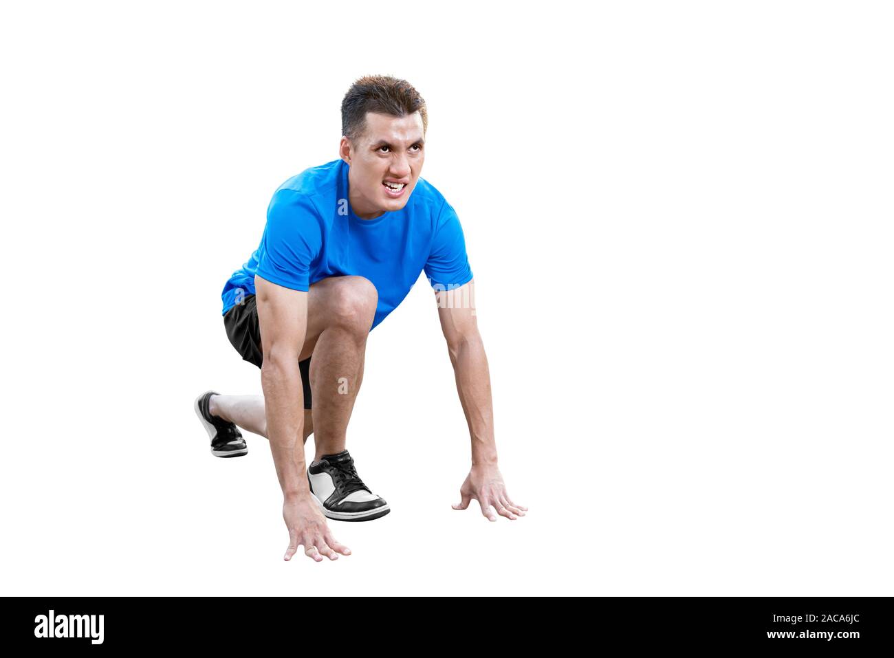 Asian runner uomo in una posizione pronta per eseguire isolate su sfondo bianco Foto Stock