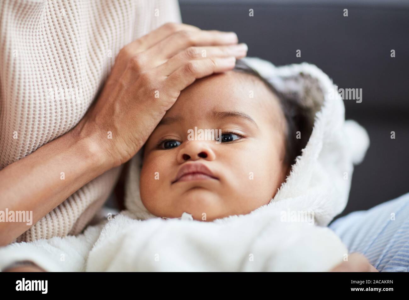 Close-up di madre mentre tiene il suo bambino su mani e accarezzare la sua testa Foto Stock