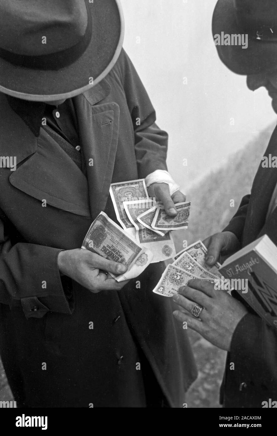 Männer mit Messekatalog und Geld auf Leipziger Messe, Sachsen, Deutschland, 1948. Gli uomini con il catalogo della mostra e denaro su Leipziger Messe, in Sassonia, Germania, 1948. Foto Stock