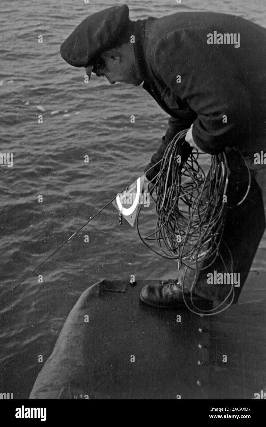 Hafenarbeiter hält Leine des Bojentauchers, Emden, Niedersachsen, Deutschland, 1950. Docker detiene il guinzaglio di boe subacqueo, Emden, Bassa Sassonia, Germania, 1950. Foto Stock
