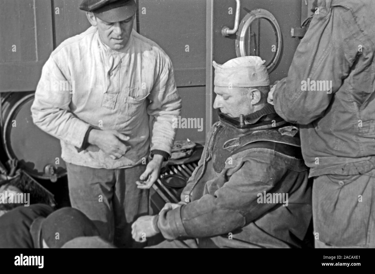 Schiffsarbeiter helfen Bojen Taucher in Taucheranzug, Emden, Niedersachsen, Deutschland, 1950. Nave lavoratori aiutare boe subacquei nella muta, Emden, Bassa Sassonia, Germania, 1950s. Foto Stock