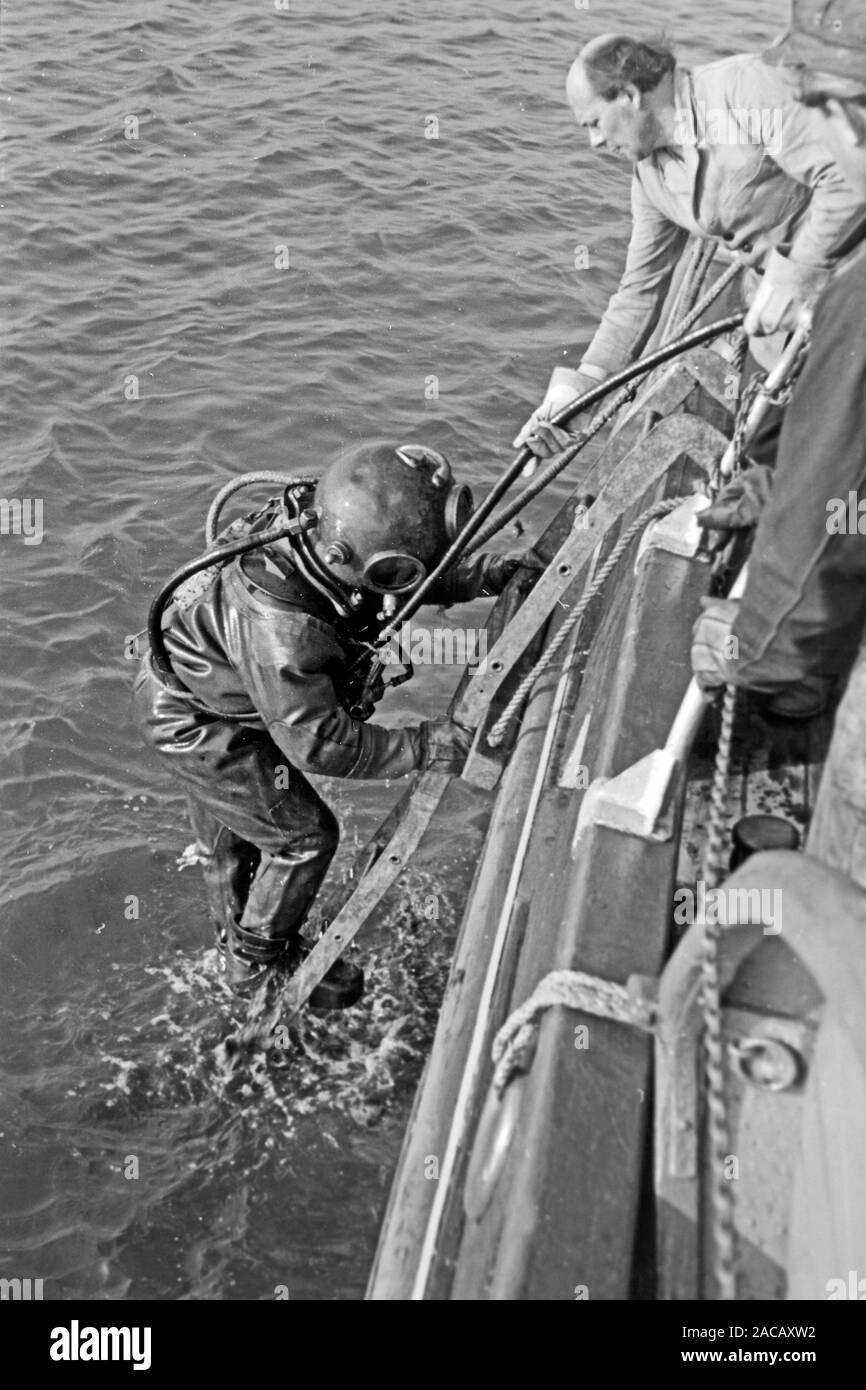 Bojentaucher steigt aus Wasser, Emden, Niedersachsen, Deutschland, 1950. Boe divers sorge dall'acqua, Emden, Bassa Sassonia, Germania, 1950. Foto Stock
