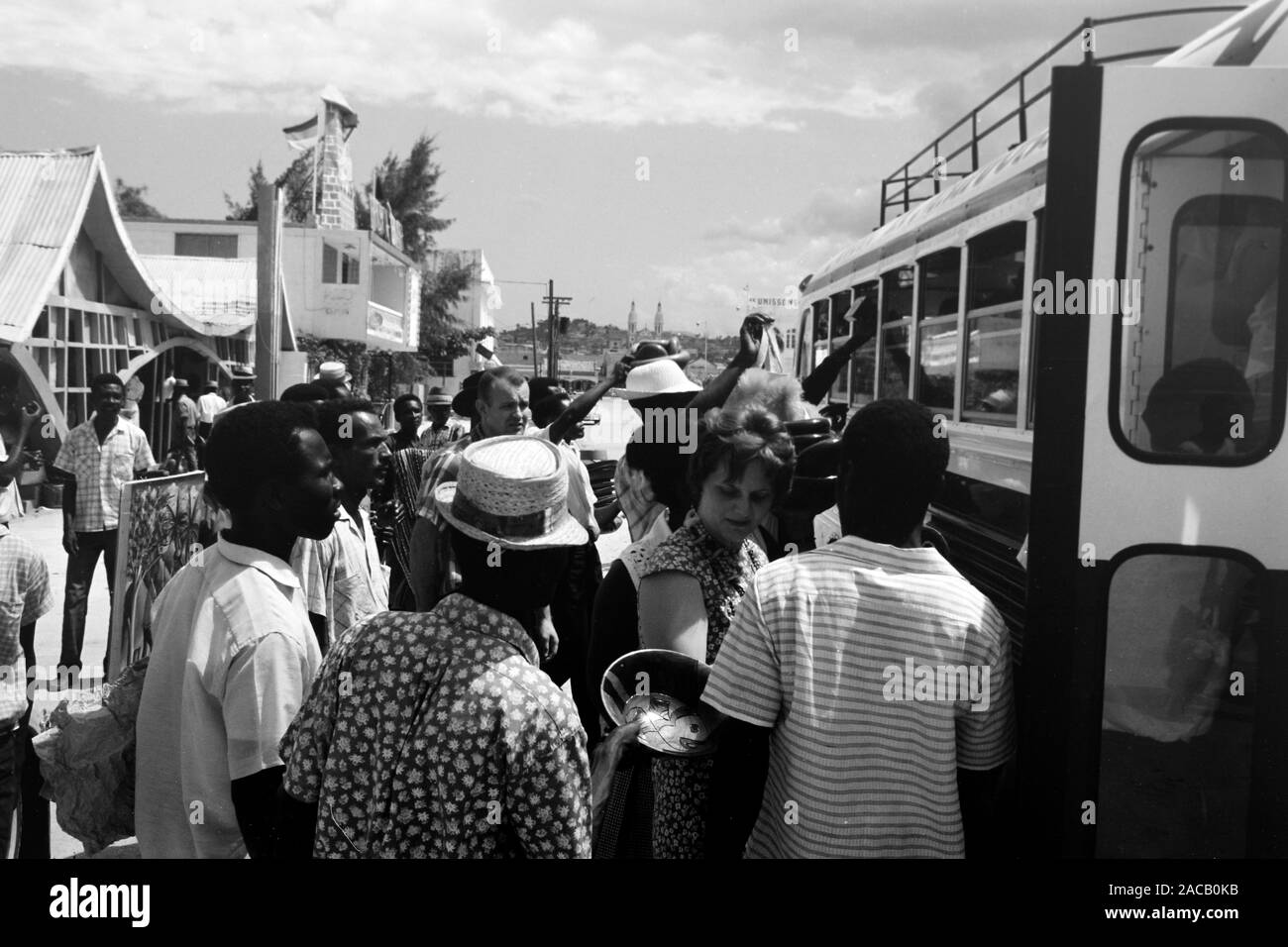 Fliegende Händler bieten ihre Waren durchreisenden Bus-Fahrgästen un, 1967. Gli operatori mobili che offrono la loro merce per i passeggeri di un autobus in transito, 1967. Foto Stock
