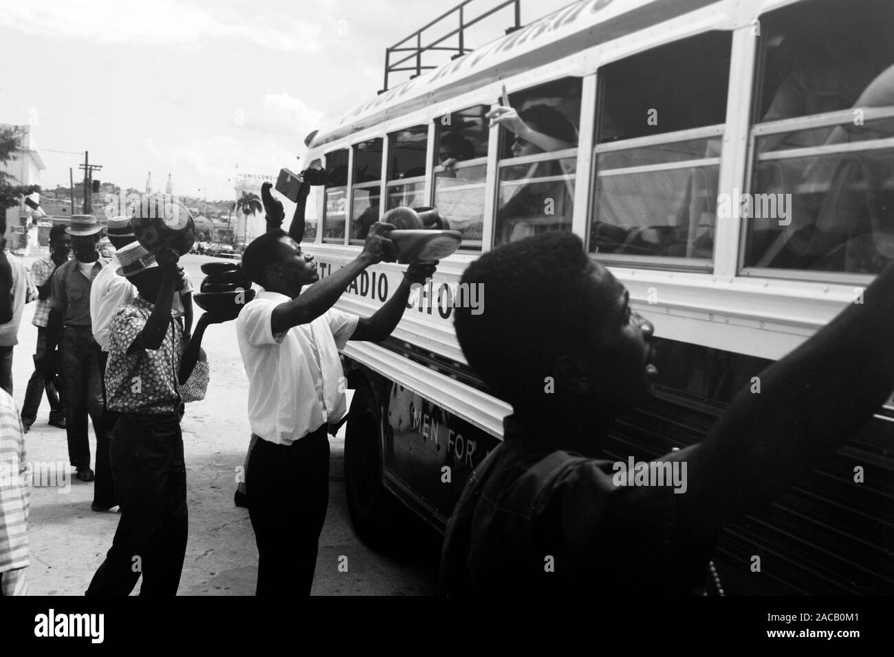 Fliegende Händler bieten ihre Waren durchreisenden Bus-Fahrgästen un, 1967. Gli operatori mobili che offrono la loro merce per i passeggeri di un autobus in transito, 1967. Foto Stock