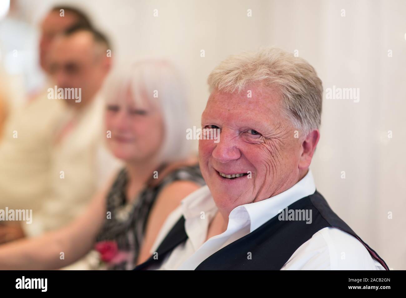 Gli ospiti dei matrimoni a sorridere e ridere e divertirsi al matrimonio colazione, lasciando i loro capelli giù dopo la cerimonia e sul banco della reception, matrimoni Foto Stock