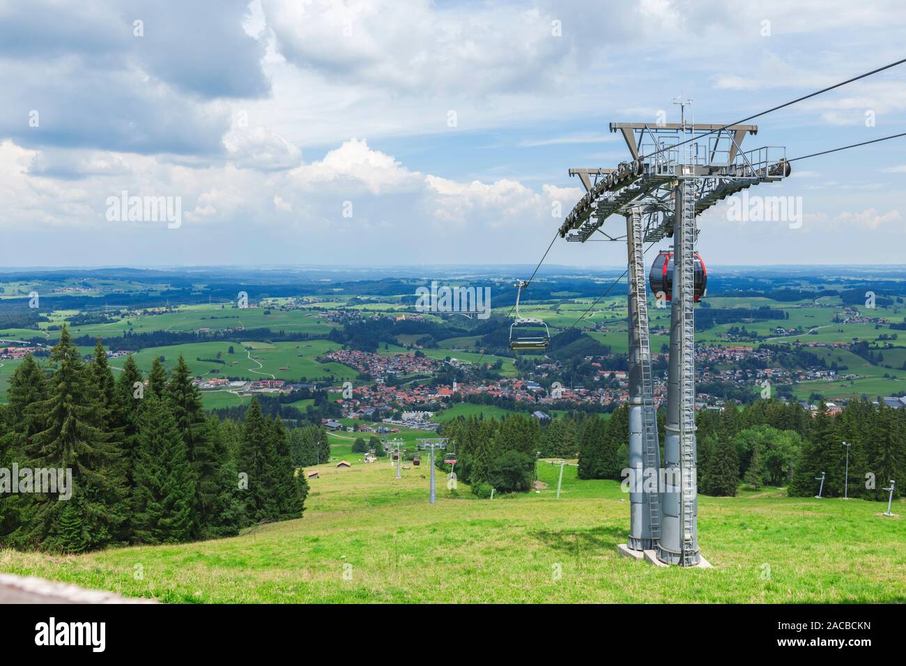 Vista del paesaggio di montagna Alpspitz sulla vallata con la piccola città Nesselwang con funivia pilastri in primo piano e di ampie vedute. Foto Stock