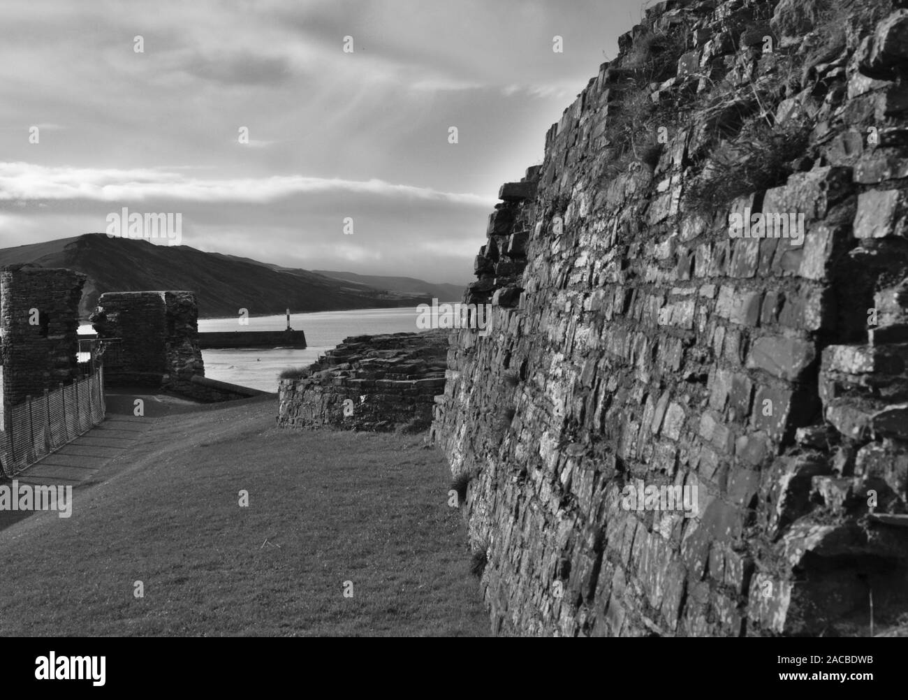 Bianco e nero: Aberystwyth Stone Jetty e Allt-Wen hill preso dalla città di castello costruito da Edoardo I nel 1277 Foto Stock