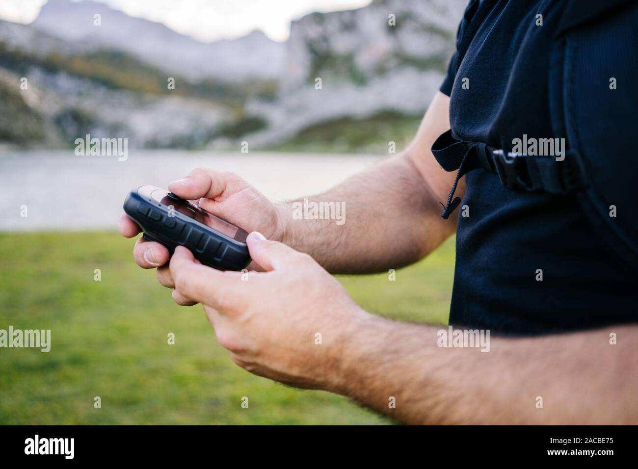 Dettaglio di un uomo con le mani in mano in possesso di un GPS di montagna Foto Stock