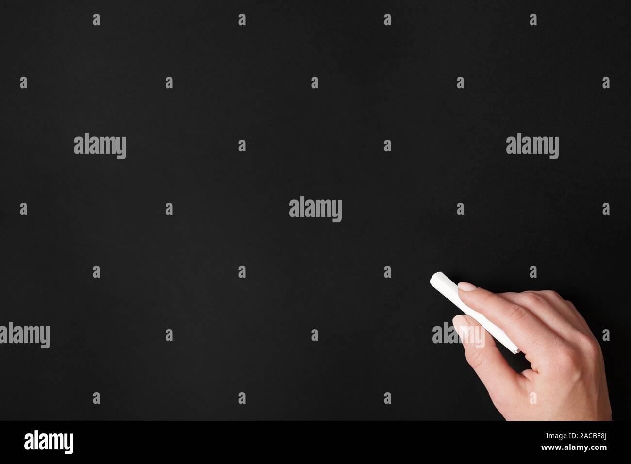 Mano azienda chalk contro vuoto sullo sfondo della lavagna Foto Stock