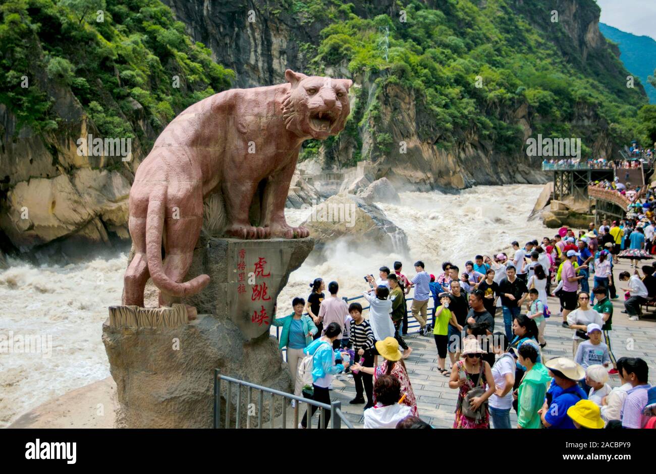 I turisti guarda acqua nel fiume Jinsha sgorga attraverso la tigre salta in gola in città Hutiaoxia, Shangri-la città, a sud-ovest della Cina di provincia dello Yunnan Foto Stock