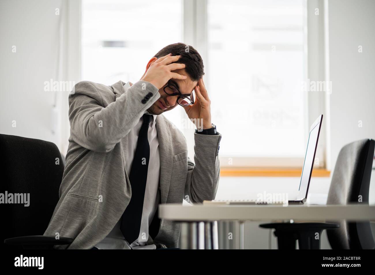 Giovane imprenditore è avere mal di testa. Foto Stock