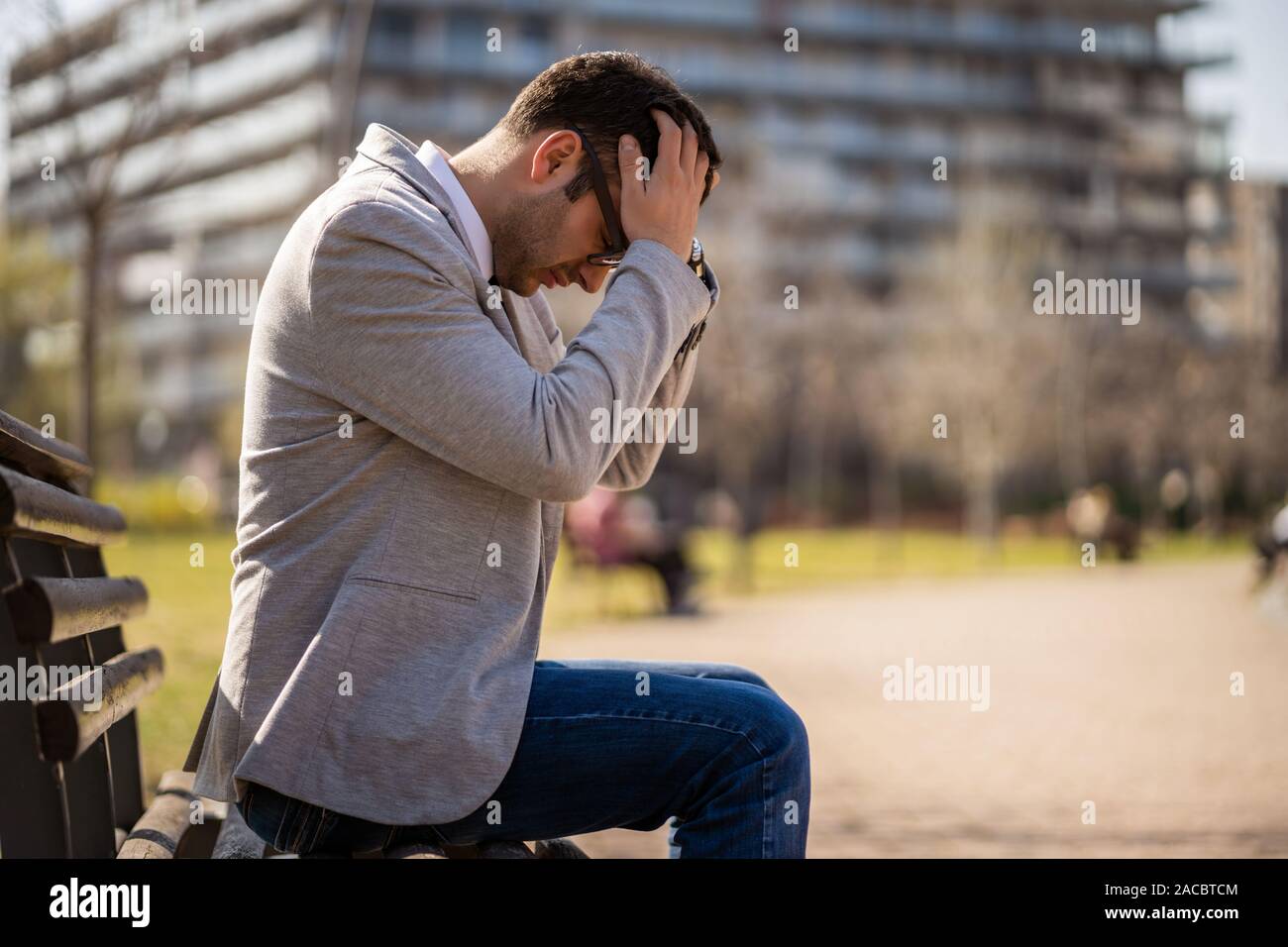 Giovane imprenditore è seduto in posizione di parcheggio dopo essere licenziato. Egli è premuto. Foto Stock
