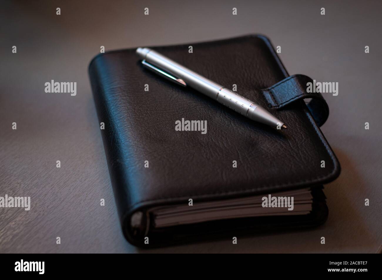 Agenda di nero e penna su grigio office tabella. close up. Foto Stock