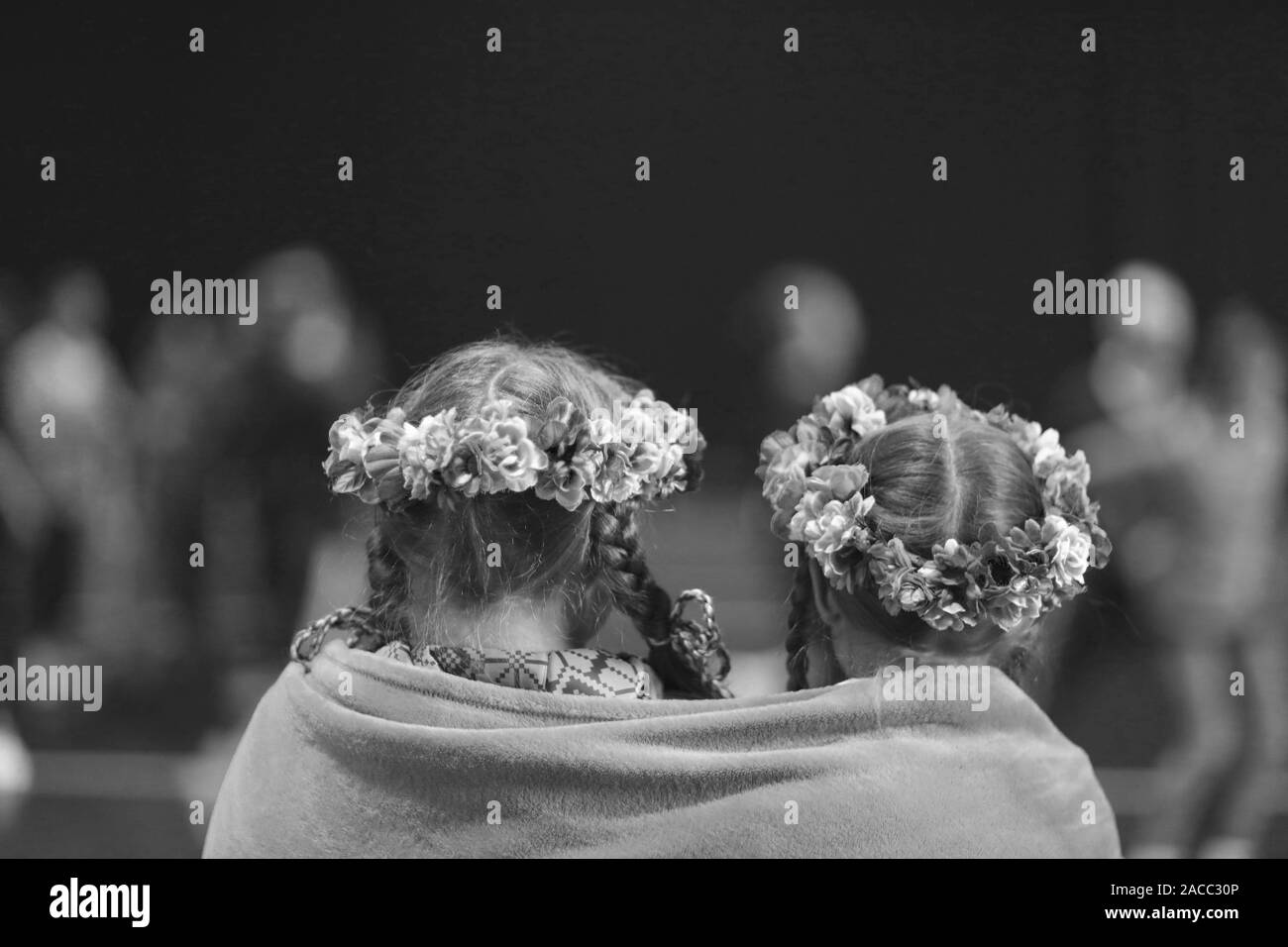 Due ragazze, i membri del gruppo di danza, con trecce e ghirlande sulla sua testa, avvolto con una coperta di vello Foto Stock