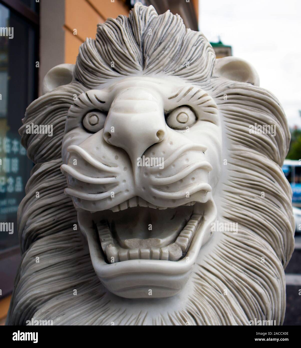 Divertenti sorridente in marmo lion statua che si trova nella parte anteriore del ristorante cinese Foto Stock