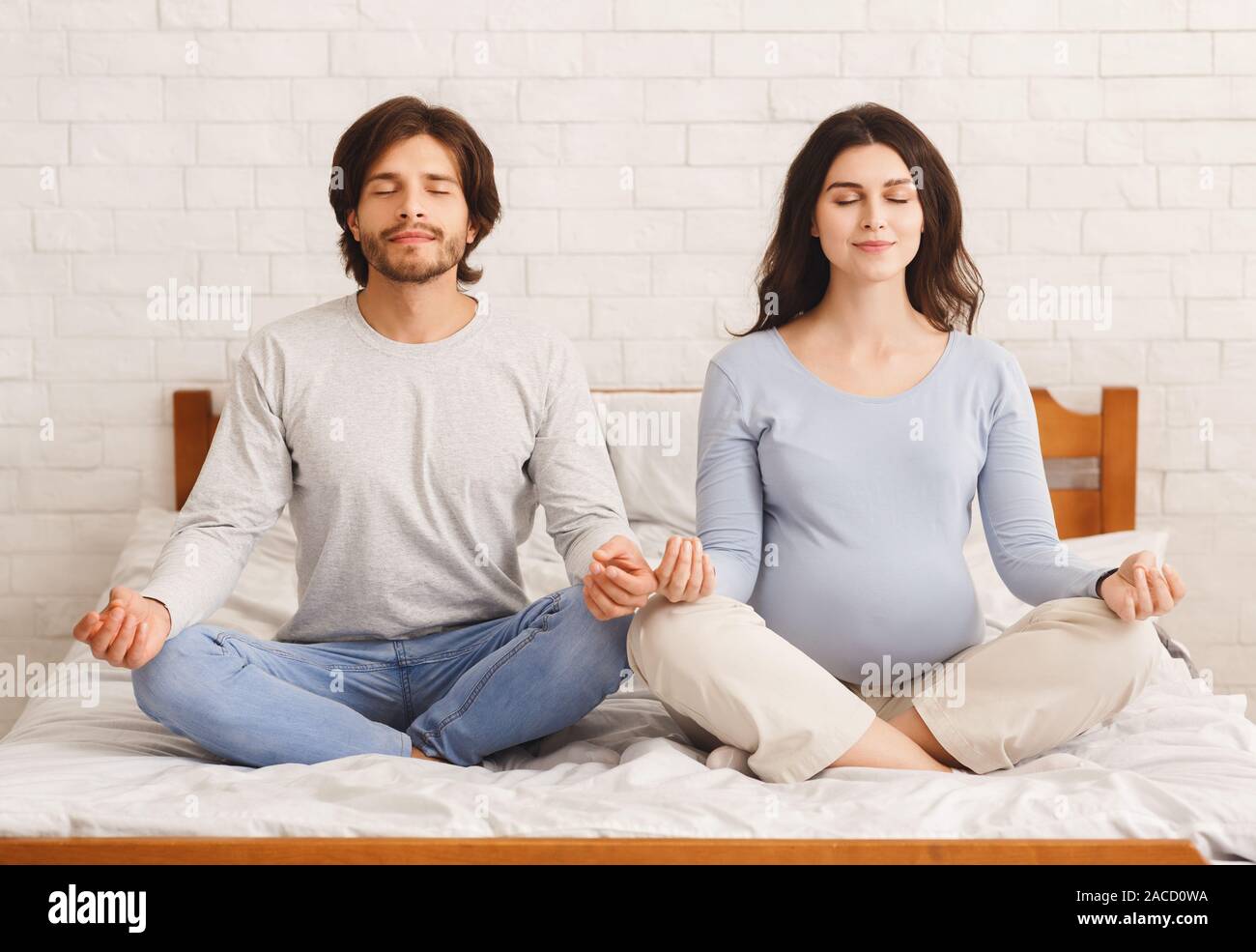 Donna incinta fare yoga esercizi di respirazione insieme con il marito Foto Stock