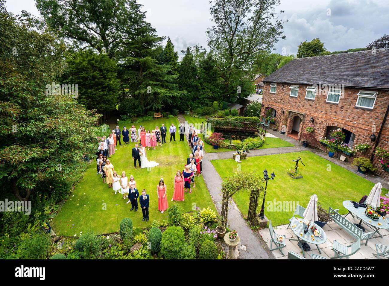 Gli sposi, gli sposi e gli ospiti del matrimonio posano per una foto all'esterno presso l'hotel Manor, B&B a Cheadle, Stoke on Trent, Staffordshire, il giorno delle nozze Foto Stock